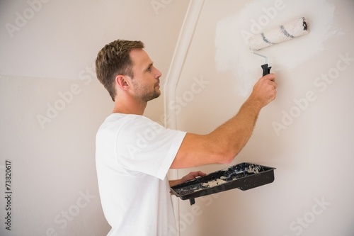 Painter painting the walls white