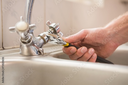 Photos Man fixing tap with pliers