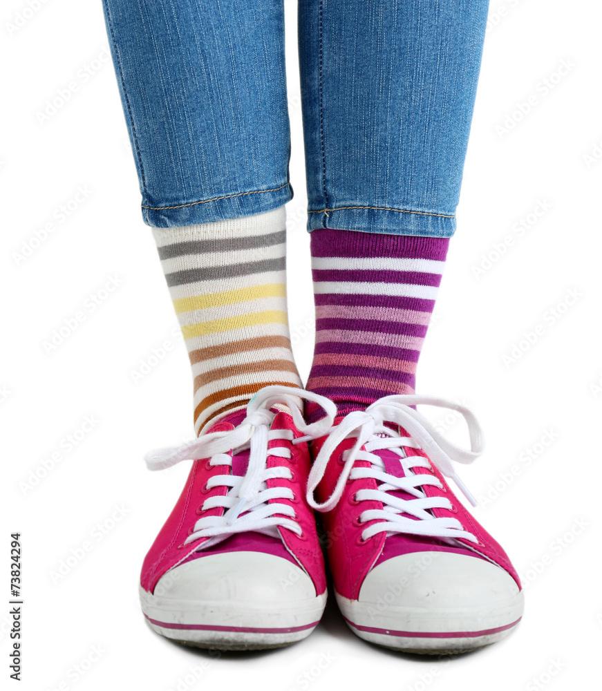 Female legs in colorful socks and sneakers isolated on white Female legs in colorful socks and sneakers isolated on white