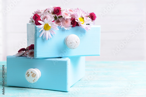 Fototapeta Naklejka Na Ścianę i Meble -  Beautiful flowers in boxes on table on light background