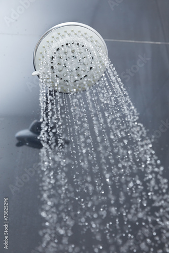 shower head in bathroom with water drops flowing