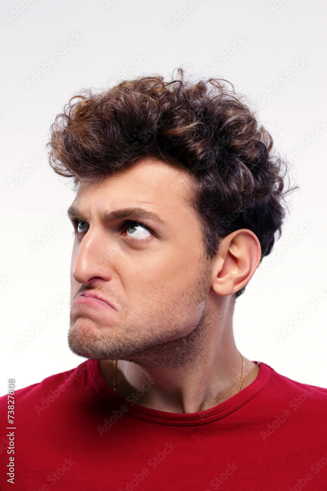 Closeup portrait of angry man looking up over gray background