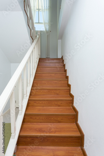 wooden staircase made from laminate wood in white modern house © sutichak