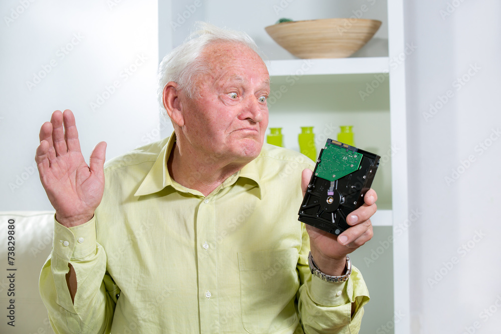 Senior man holding hard disk Senior man holding hard disk