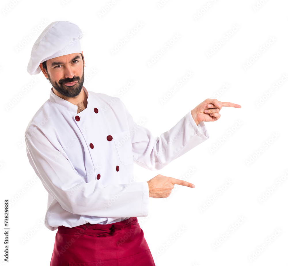 Chef pointing to the lateral over white background Chef pointing to the lateral over white background