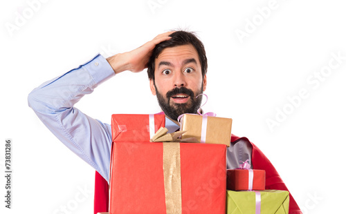 Surprise businessman dressed like superhero holding gifts