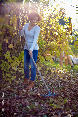 Obraz na płótnie Farmer lady raking, cleaning the garden