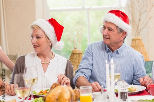 Cute mature couple in santa hat at christmas dinner