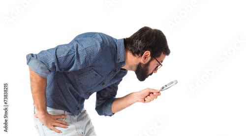 Young hipster man with magnifying glass