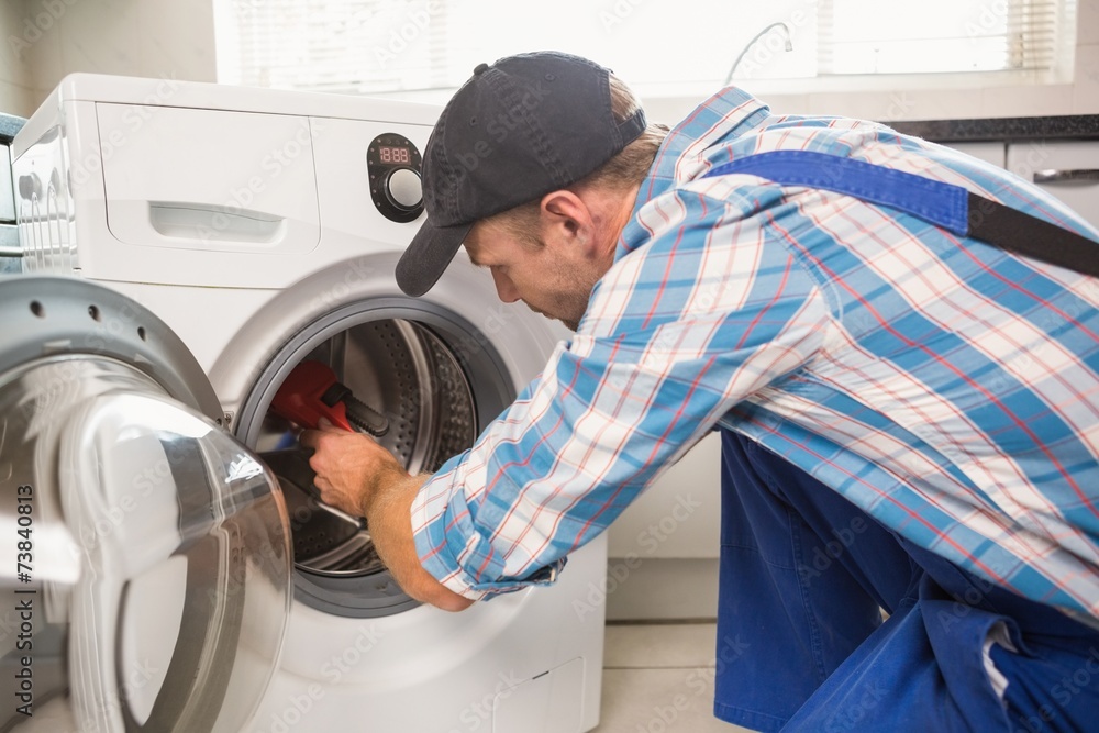 Handyman fixing a washing machine Handyman fixing a washing machine