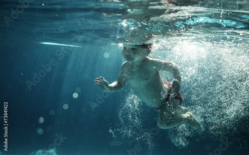 baby in water park swimming underwater