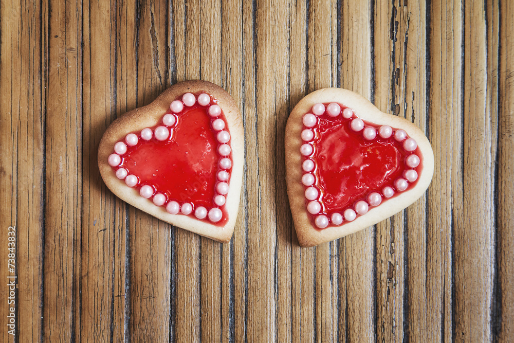 Two red hearts cookies on wooden background Two red hearts cookies on wooden background