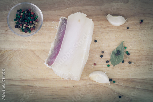 raw bacon with spices on wooden table. tinted