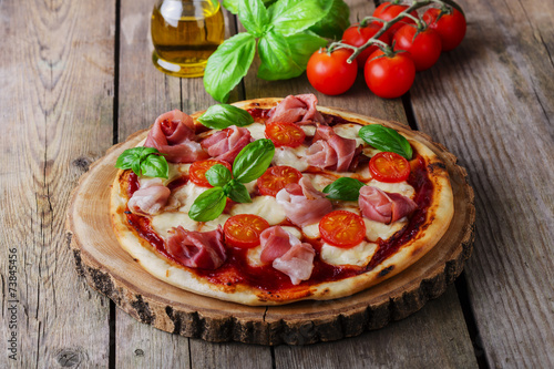 pizza with mozzarella and prosciutto, tomatoes