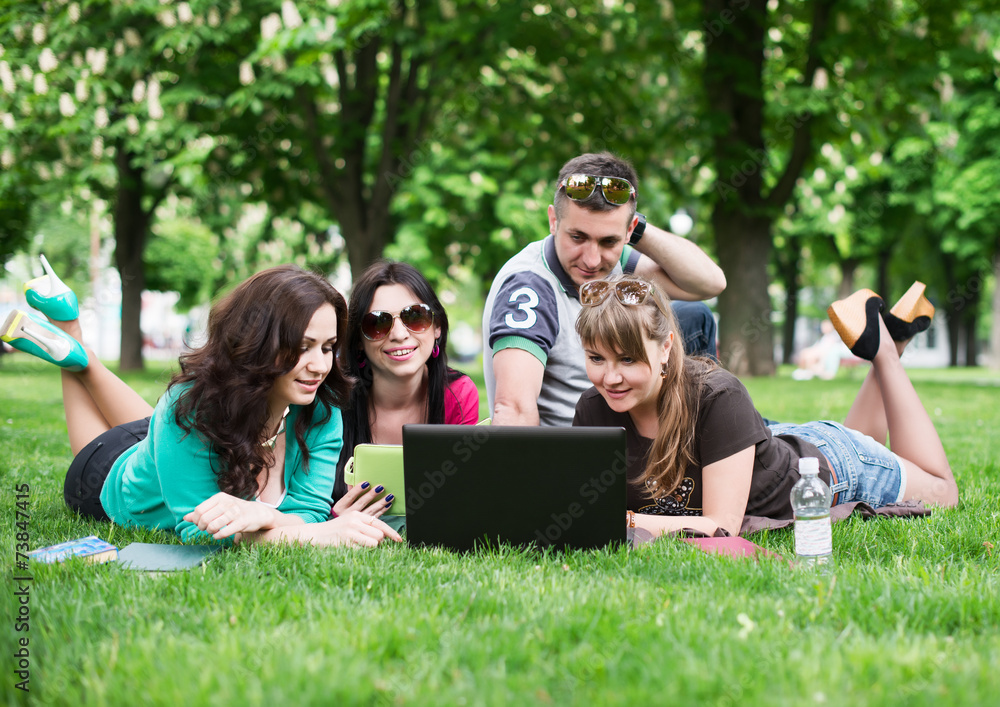 Group of young college students sitting on grass Group of young college students sitting on grass