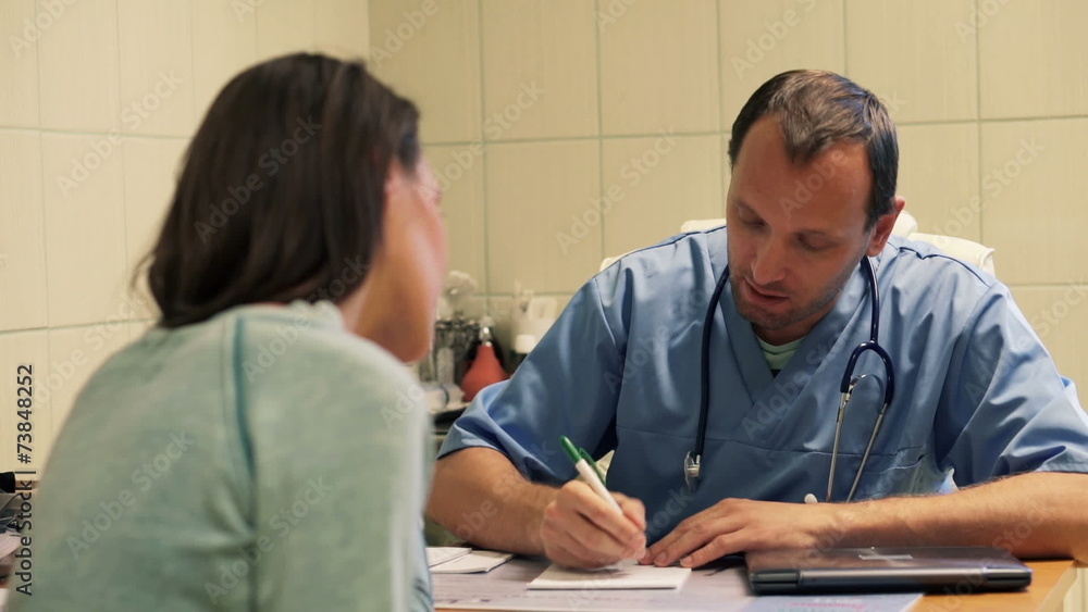 Doctor explaining and writing rx prescription for patient in hos Doctor explaining and writing rx prescription for patient in hos