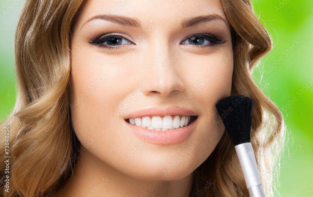 Smiling woman with make up brush, outdoor Smiling woman with make up brush, outdoor