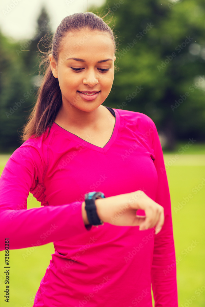 smiling young woman with heart rate watch smiling young woman with heart rate watch