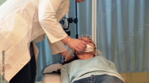 Doctor preparing woman for brain scan in hospital photo