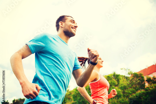 smiling couple running outdoors