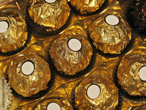 Chocolates with round shape in golden foil and labels
