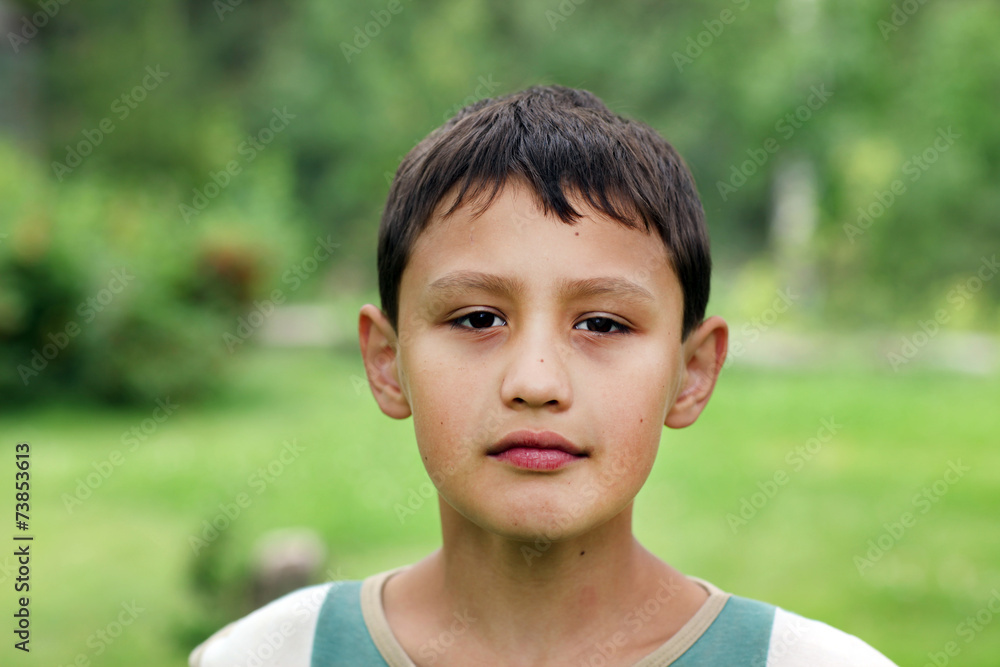 little boy 10 years old against green grass colors little boy 10 years old against green grass colors