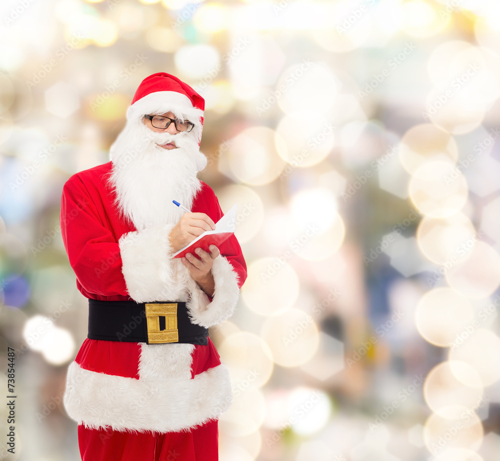 man in costume of santa claus with notepad man in costume of santa claus with notepad
