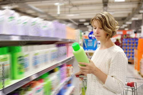 woman shopping and choosing goods at supermarket photo