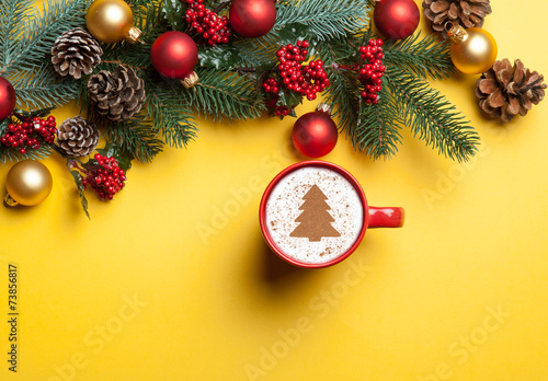 cappuccino and christmas tree shape and pine branch on yellow ba