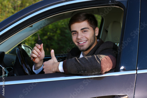 Man with car key in car