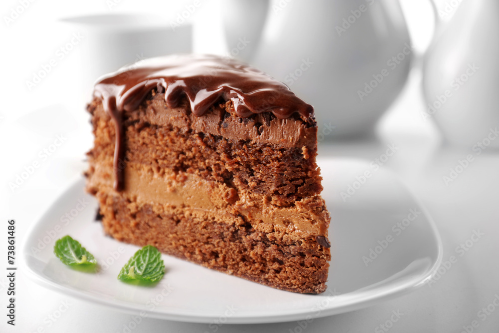 Delicious chocolate cake on plate on table on light background Delicious chocolate cake on plate on table on light background