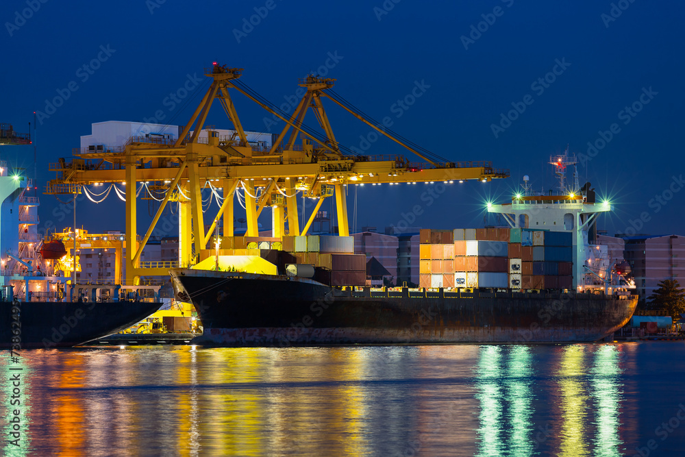 Gantry crane loading and unloading cargo container from cargo ship at port to show global international logistics and transportation by cargo ship and cargo container, Logistic import export concept. Gantry crane loading and unloading cargo container from cargo ship at port to show global international logistics and transportation by cargo ship and cargo container, Logistic import export concept.