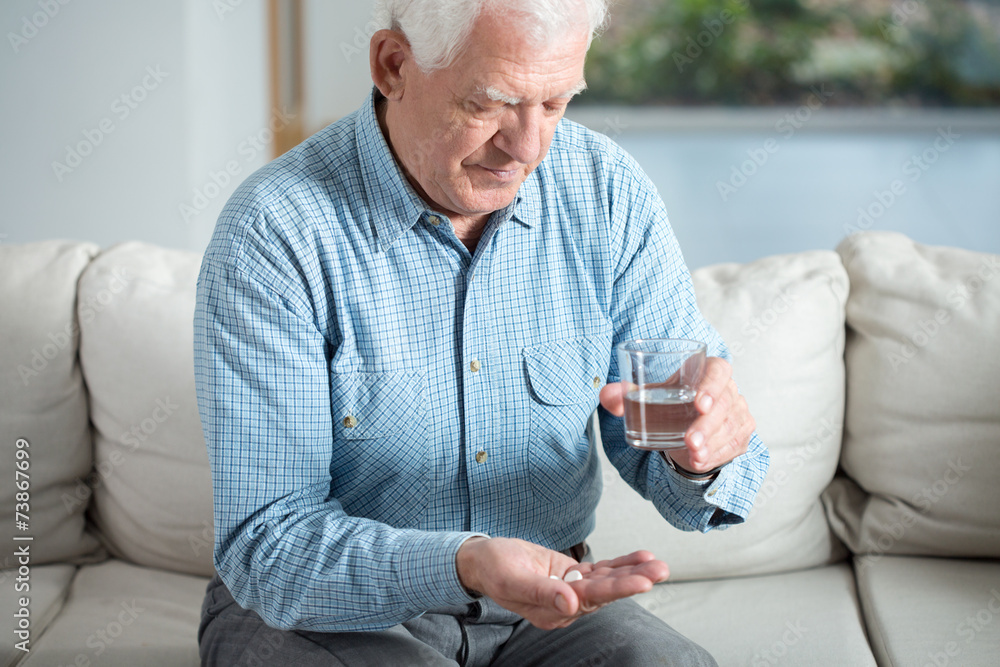 Ill senior man taking pill Ill senior man taking pill