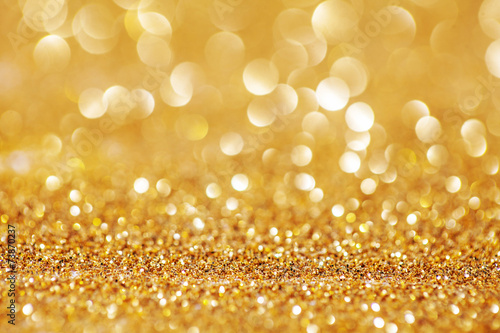 Golden Glitter for Christmas Background with Blurred Lights.