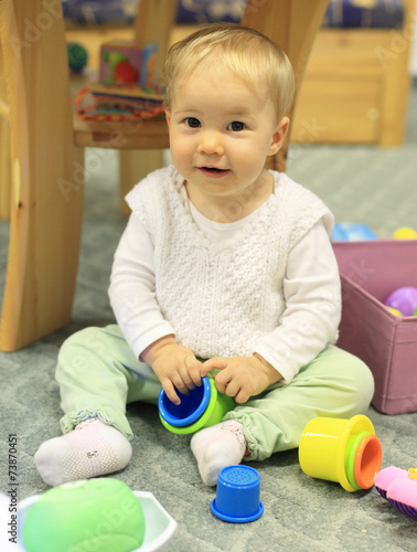 Young cute child playing on floor indoor