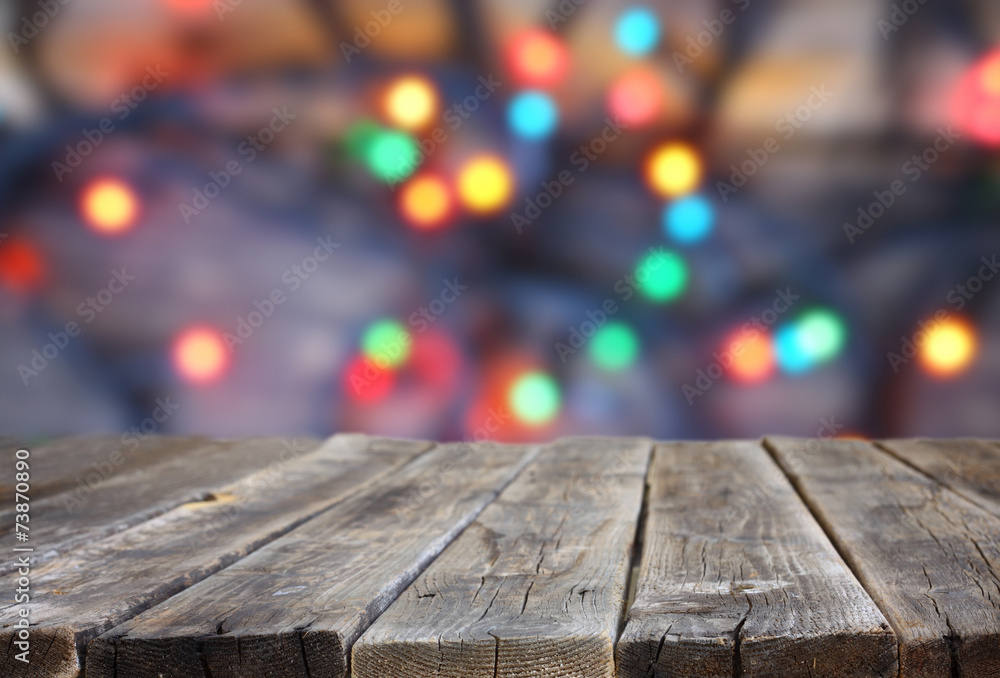 Fototapeta premium rustic wood table in front of glitter colorfull bright bokeh lig