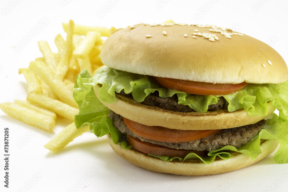 Big hamburger and fried potatoes isolated on white background Big hamburger and fried potatoes isolated on white background