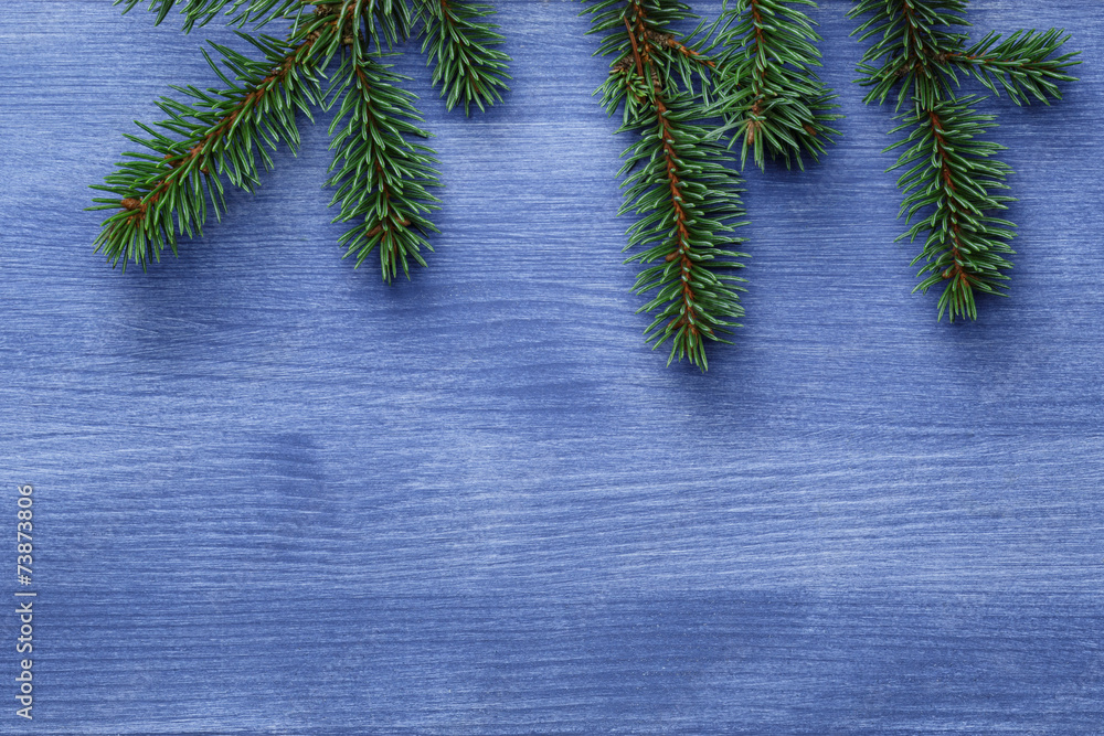 christmas tree branch on blue wood table christmas tree branch on blue wood table
