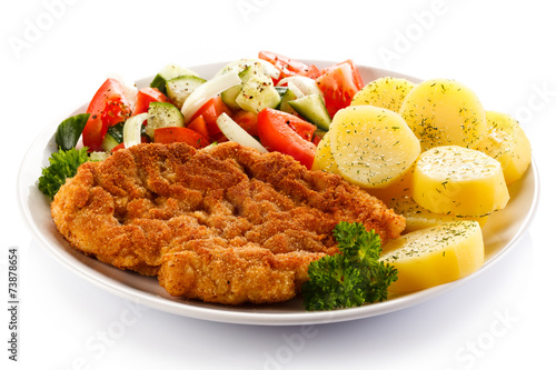 Fried pork chop, boiled potatoes and vegetable salad