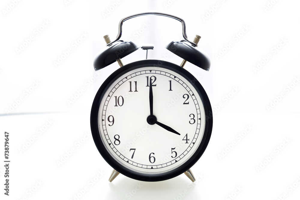 Oldfashioned black glossy alarm clock showing 4 o'clock Oldfashioned black glossy alarm clock showing 4 o'clock
