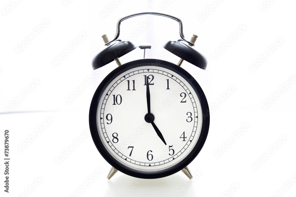 Oldfashioned black glossy alarm clock showing 5 o'clock Oldfashioned black glossy alarm clock showing 5 o'clock