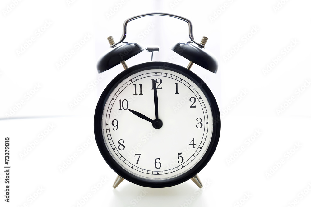 Oldfashioned black glossy alarm clock showing 10 o'clock Oldfashioned black glossy alarm clock showing 10 o'clock