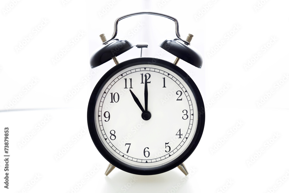 Oldfashioned black glossy alarm clock showing 11 o'clock Oldfashioned black glossy alarm clock showing 11 o'clock