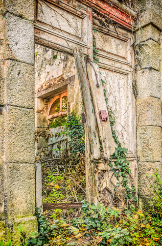 Fototapeta Naklejka Na Ścianę i Meble -  Broken door and medieval abandoned house in village
