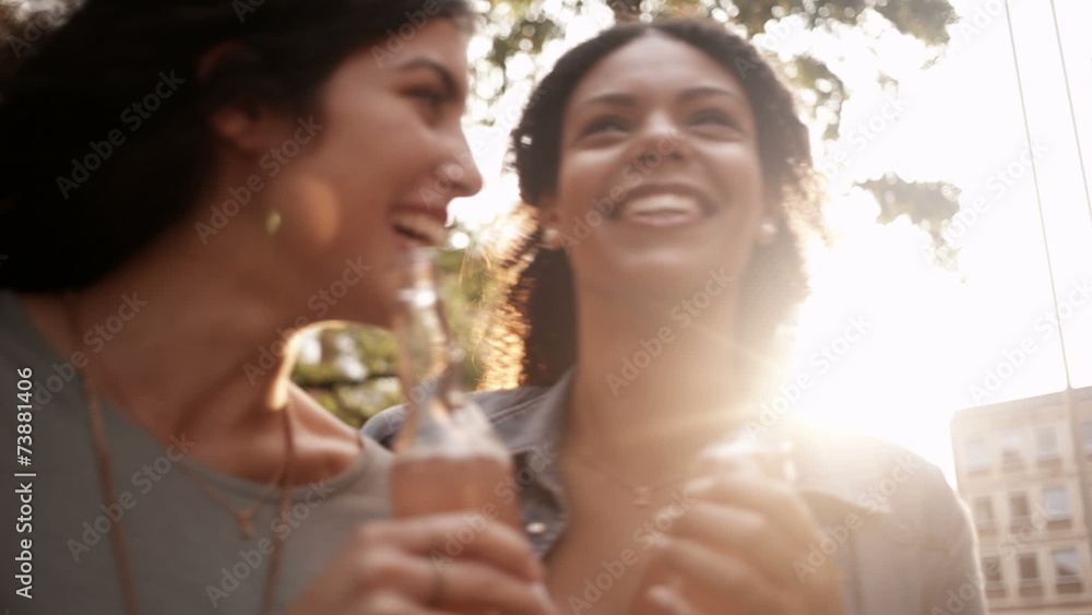 Mixed race Girl friends enjoying pink lemonade drinks together o Mixed race Girl friends enjoying pink lemonade drinks together o