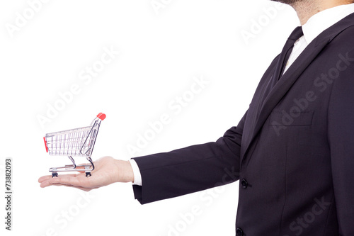 Business man holding a shopping cart, isolated over white backgr