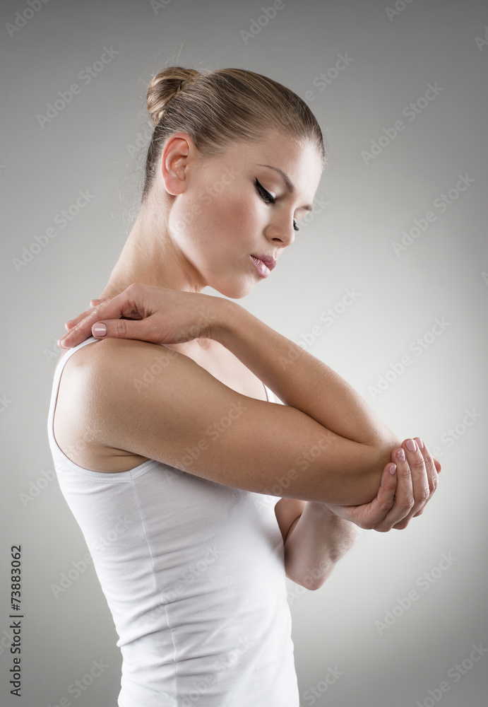 Fototapeta premium Young woman having joint pain and massaging her elbow