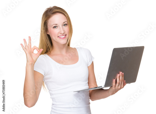 Woman use of notebook and ok sign