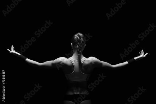 Athletic young woman showing muscles of the back © Restyler