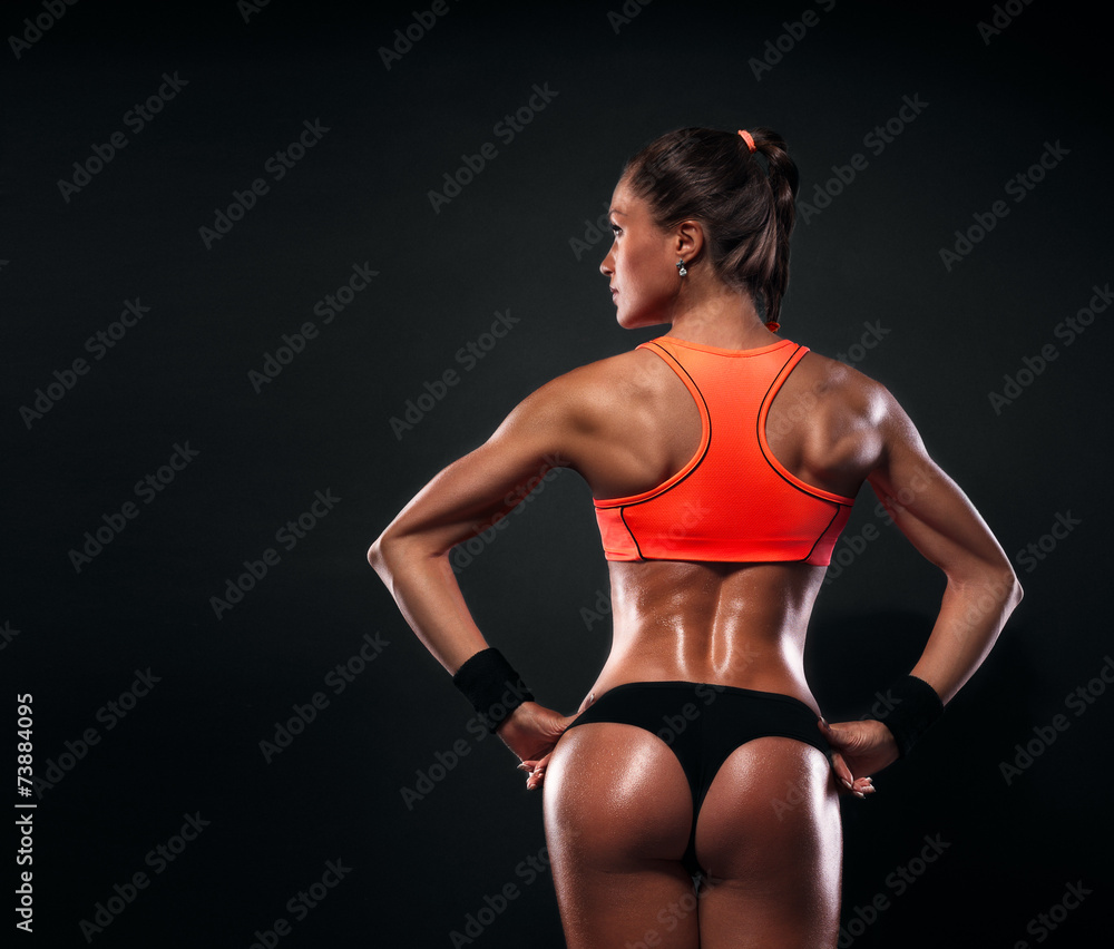 Obraz premium Athletic young woman showing muscles of the back